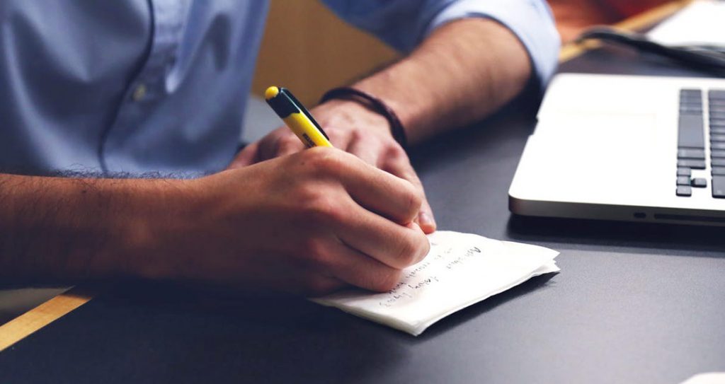 A person writing content Ideas down on a pad