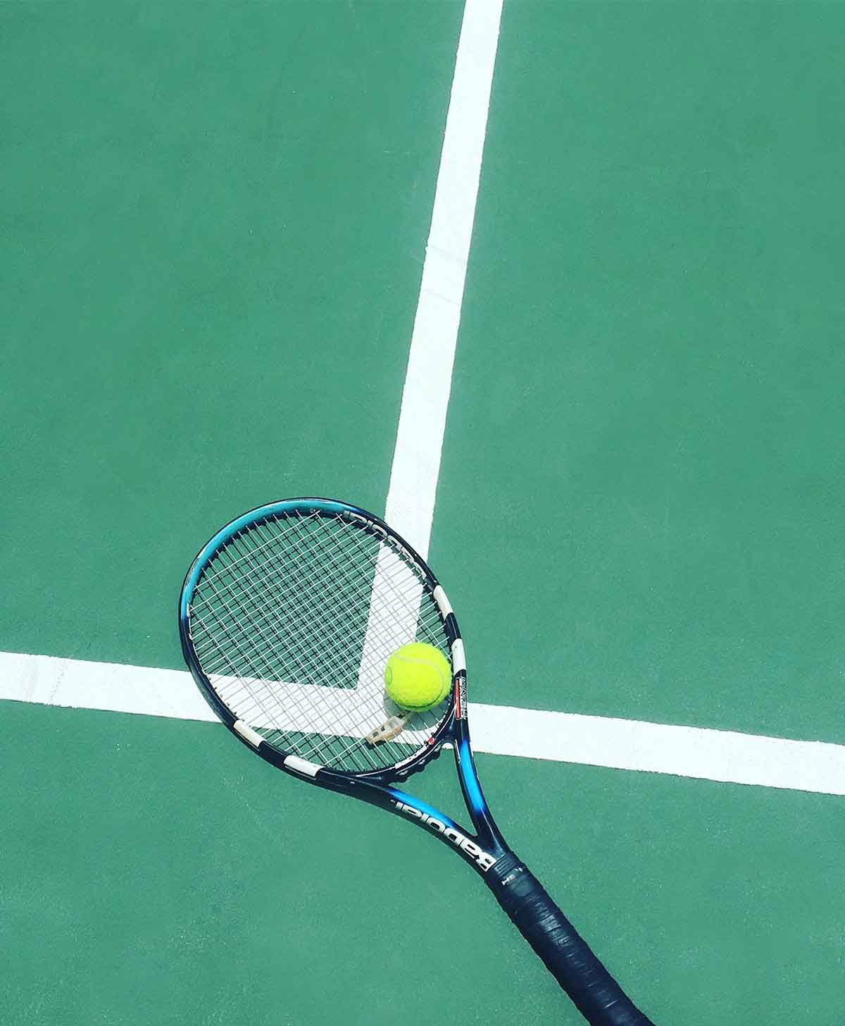Tennis racket and ball on court