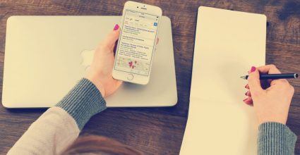 A person copying text to note pad from a mobile